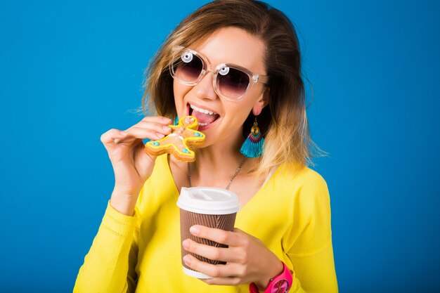 Mulher jovem e bonita hippie, comendo biscoitos, bebendo café