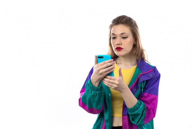 Mulher jovem e bonita jaqueta colorida e segurando o smartphone