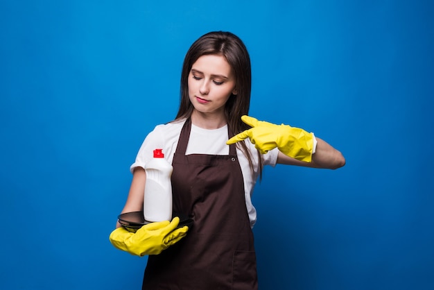 Mulher jovem e bonita no avental com pratos lavados e sabão. Um frasco de detergente com um rótulo em branco em uma pilha de pratos limpos