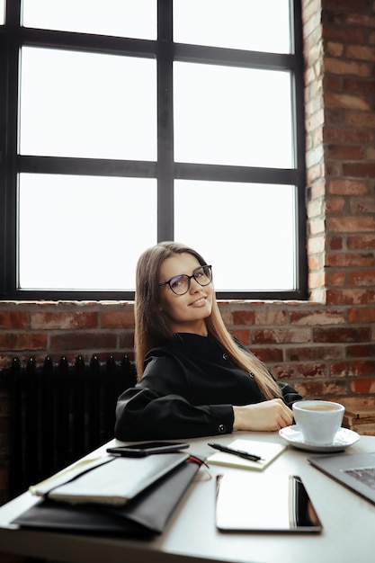 Foto grátis mulher jovem e bonita no escritório em casa. trabalhando em casa. conceito de teletrabalho