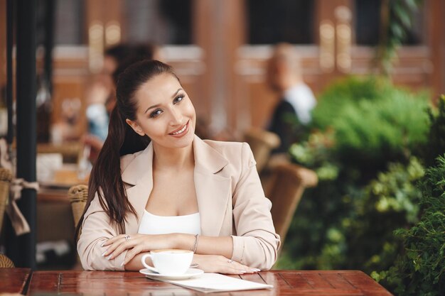 mulher jovem e bonita no terraço do café ao ar livre