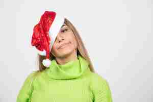 Foto grátis mulher jovem e bonita posando com chapéu vermelho de papai noel.