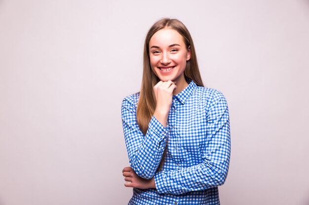 Mulher jovem e bonita sorrindo isolada na parede branca