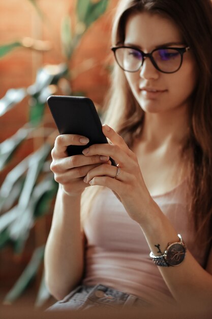 Mulher jovem e bonita usando smartphone em casa