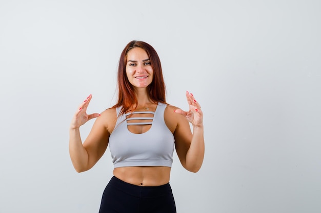 Mulher jovem e desportiva com cabelo comprido e top cinza