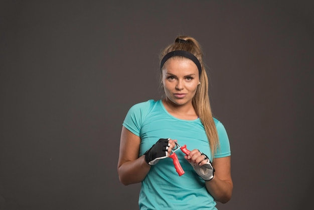 Mulher jovem e desportiva com uma mão a esticar um chiclete