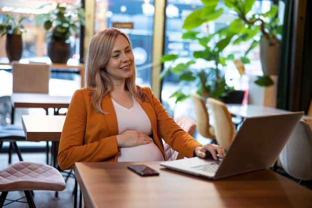 Mulher jovem e grávida no trabalho