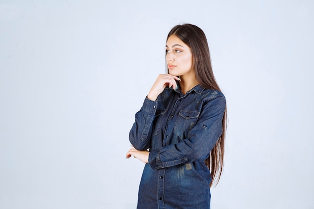 Mulher jovem em camisa jeans fazendo poses neutras e sedutoras sem reações