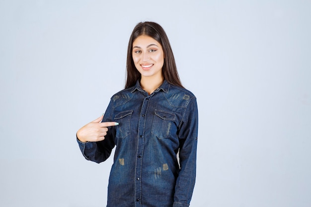 Mulher jovem em camisa jeans sorrindo e fazendo careta