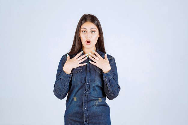 Mulher jovem em camisa jeans sorrindo e fazendo careta