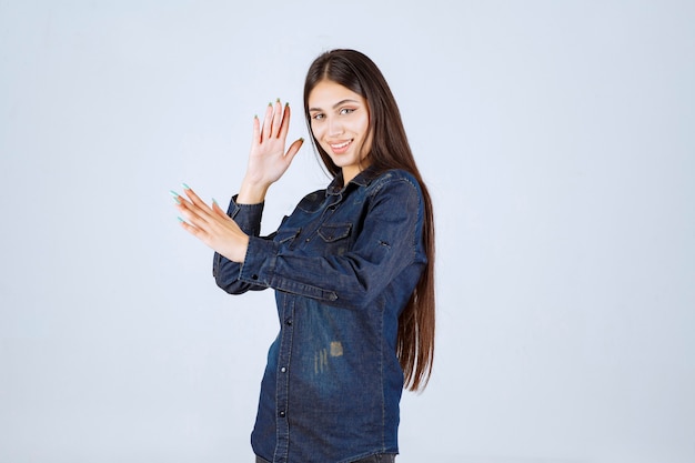 Mulher jovem em camisa jeans sorrindo e fazendo careta