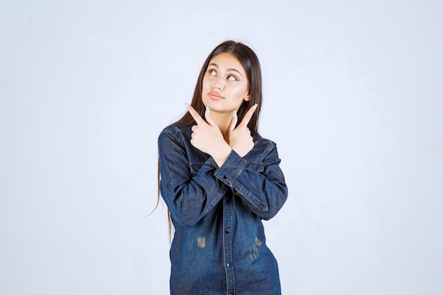 Mulher jovem em camisa jeans tentando prevenir e impedir algo