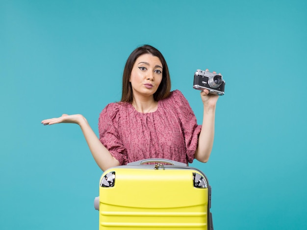 Mulher jovem em férias tirando foto com a câmera no fundo azul viagem mar viagem mulher férias no exterior