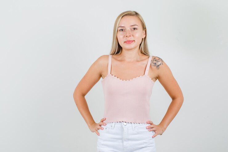 Foto grátis mulher jovem em pé com as mãos na cintura em uma camiseta