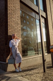 Mulher jovem em pé na rua em frente ao café