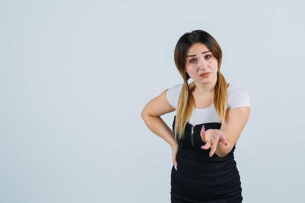 Mulher jovem esticando a mão em gesto de questionamento