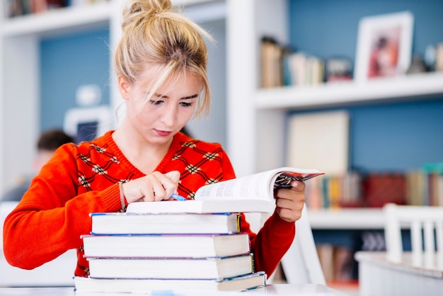 Foto grátis mulher jovem, estudar, em, biblioteca