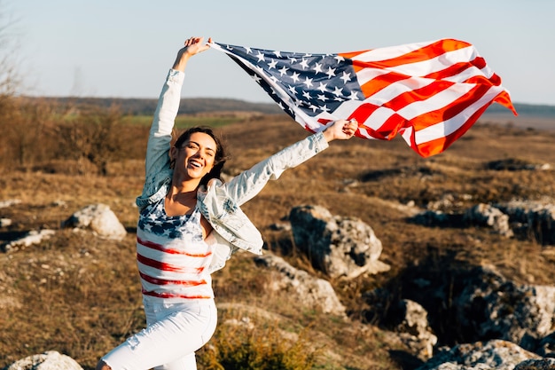 Foto grátis mulher jovem, executando, com, vibrar, bandeiras americanas