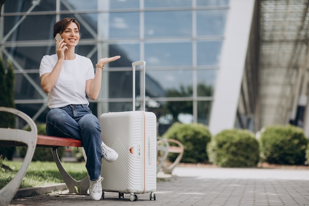 Mulher jovem falando ao telefone no aeroporto