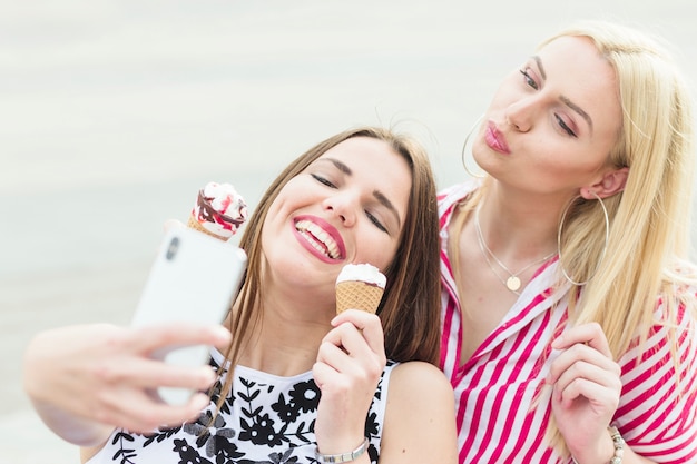 Mulher jovem, fazendo beicinho, com, dela, amigo, levando, selfie, de, cellphone