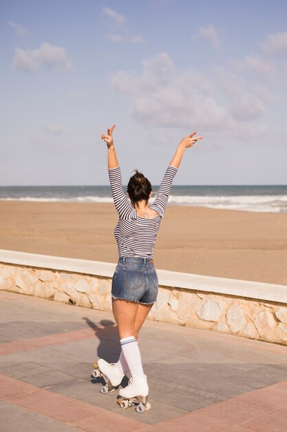 Mulher jovem, fazendo sinal paz, gesto, andar, ligado, a, lado, passeio, perto, a, praia