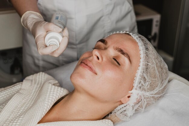 Mulher jovem fazendo tratamento para a pele do rosto no spa