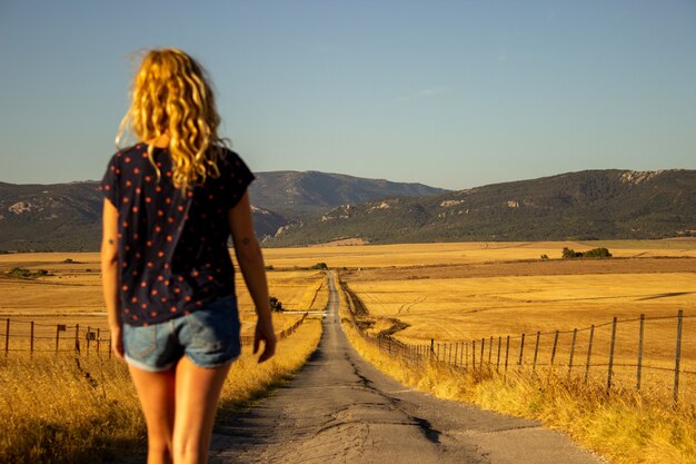 Mulher jovem feliz andando na zona rural