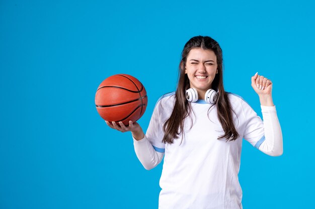 Mulher jovem feliz de frente com basquete