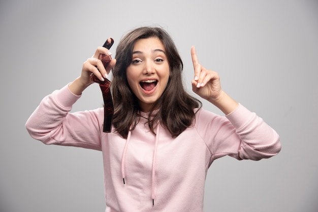 Mulher jovem feliz segurando a tira de filme.