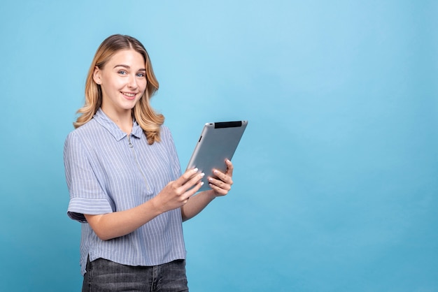 Foto grátis mulher jovem feliz, segurando um tablet