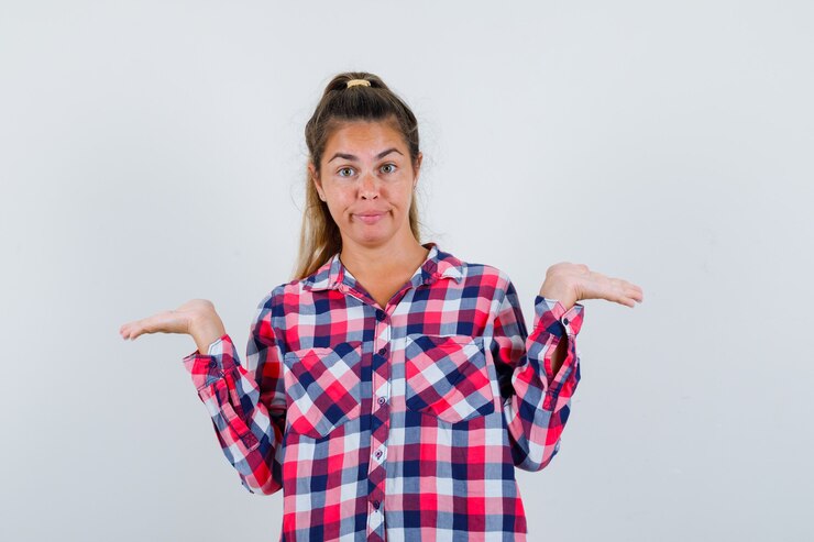 Foto grátis mulher jovem fingindo mostrar algo em uma camisa casual e parecendo confusa. vista frontal.
