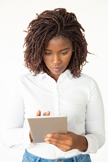 Foto grátis mulher jovem focada com tablet pc