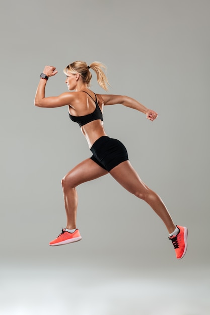 Mulher jovem forte esportes correndo isolado