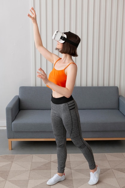 Foto grátis mulher jovem jogando videogame usando óculos de realidade virtual