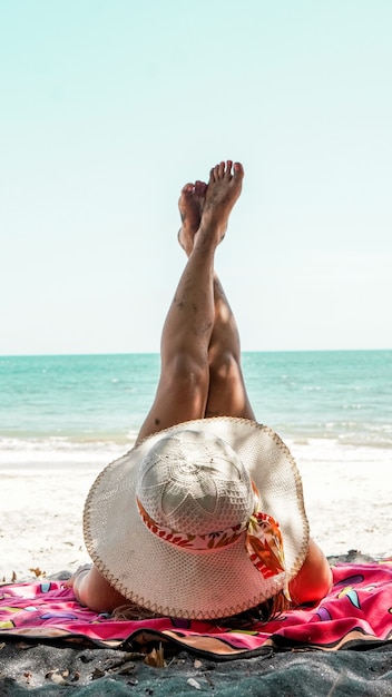 Foto grátis mulher jovem latina mostrando as pernas enquanto estava deitada na praia