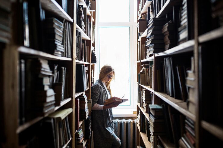 Foto grátis mulher jovem, leitura, entre, bookcases