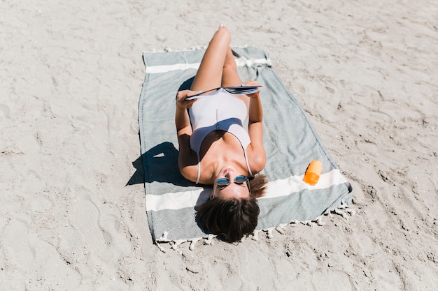 Foto grátis mulher jovem, leitura, ligado, praia arenosa