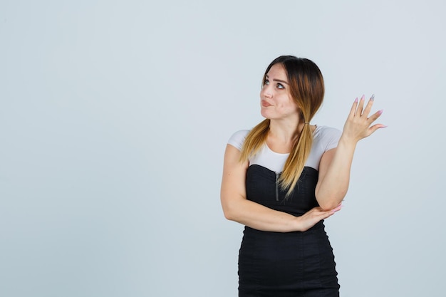 Mulher jovem levantando a mão em um gesto perplexo