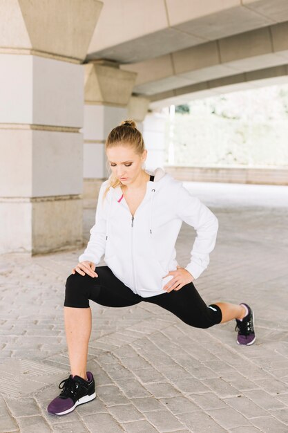 Mulher jovem, lunging, perto, pilares