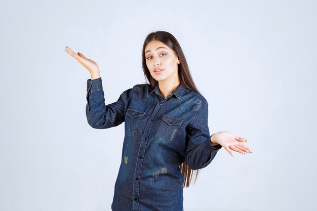 Mulher jovem mostrando algo em sua mão aberta