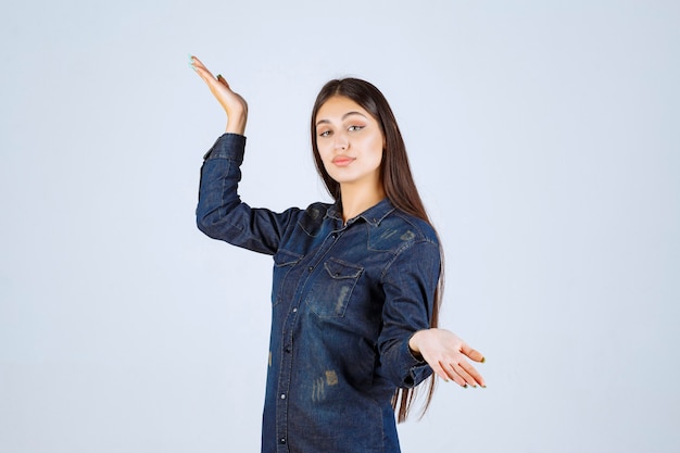 Mulher jovem mostrando algo em sua mão aberta