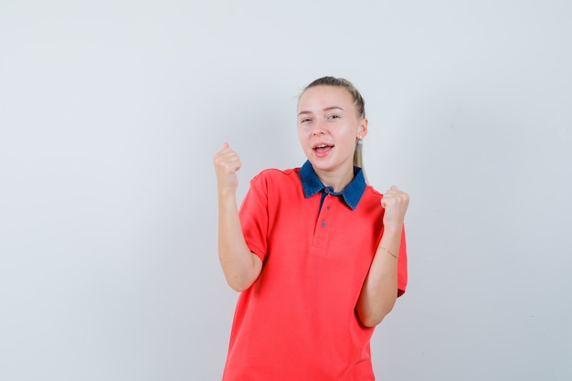 Foto grátis mulher jovem mostrando gesto de vencedor em camiseta e parecendo feliz