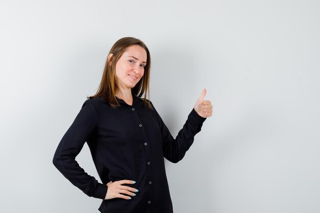 Mulher jovem mostrando os polegares para cima e parecendo feliz