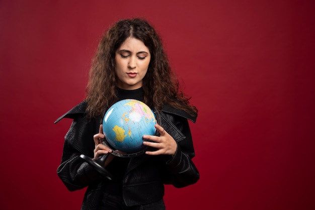 Mulher jovem olhando para o globo.