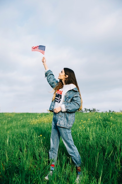 Mulher jovem, olhar, bandeira americana pequena, em, braço