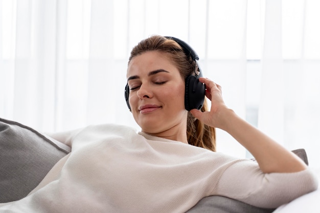 Foto grátis mulher jovem ouvindo música com seus fones de ouvido