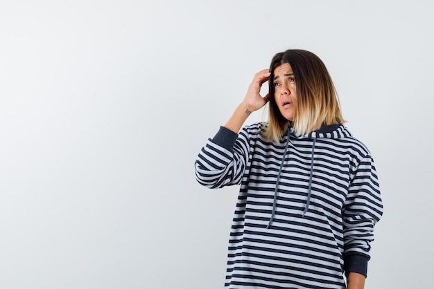 Mulher jovem pensativa sobre fundo branco