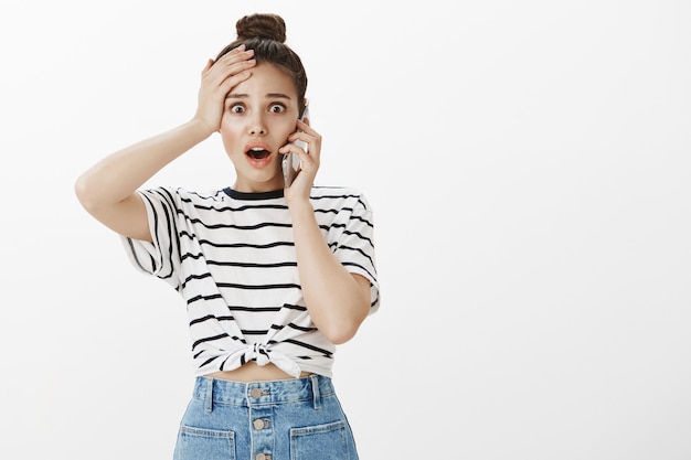 Foto grátis mulher jovem perturbada e preocupada recebe más notícias pelo telefone celular, em pânico