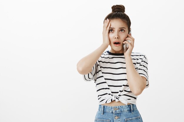 Foto grátis mulher jovem perturbada e preocupada recebe más notícias pelo telefone celular, nervosa