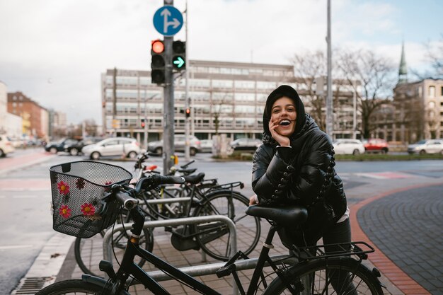 Mulher jovem posando em um estacionamento com bicicletas